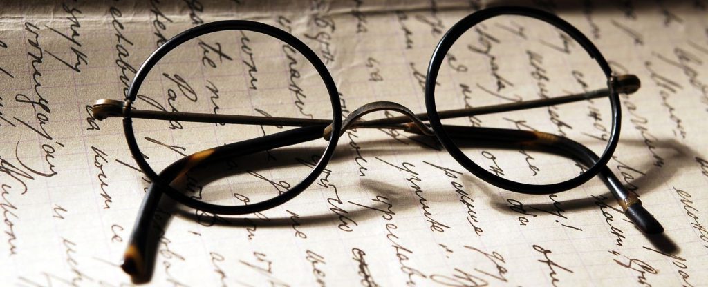 Harry Potter's glasses placed on the top of written paper.