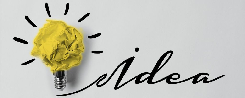 A creative concept featuring a yellow, crumpled paper shaped like a light bulb, with the word 'idea' written beside it.