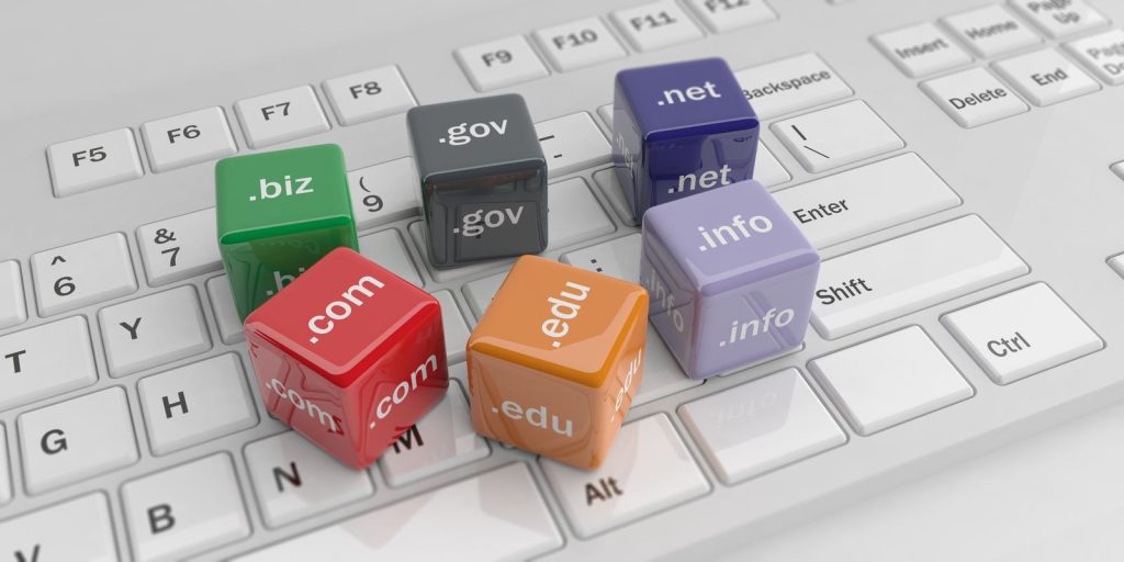 Colorful cubes displaying various types of top-level domains placed over the keyboard.