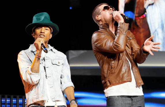 Pharrell Williams and Robin Thicke singing on stage together.
